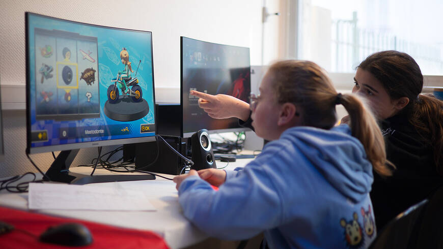 deux jeunes filles devant un écran d'ordinateur
